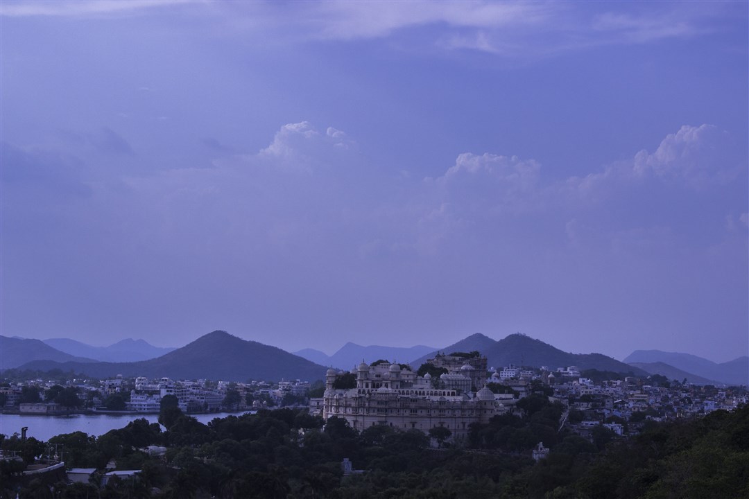 I decided to walk a bit. The road was on a higher ground and I could clearly see the Palace from a distance. To the left is Lake Pichola and the mountain range in the background is the Aravalli range. 